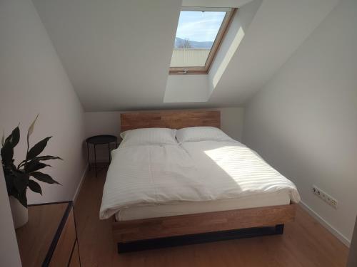 Łóżko w małym pokoju z oknem w obiekcie Apartament "Nad Niwką 6" w Bielsku Białej