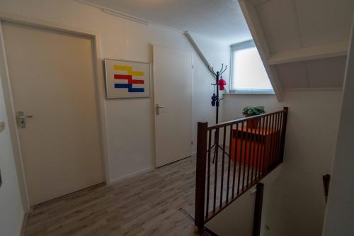 萊茵河畔米靈恩的住宿－de lange adem，一条空的走廊,有楼梯和门