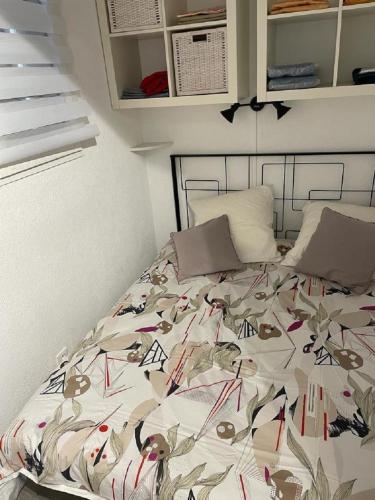 un lit avec une couette dessus dans une chambre dans l'établissement Entre ST-RAPHAEL et ST-TROPEZ. Studio pieds dans l'eau, à partir de 600 Euros/semaine., à Saint-Aygulf
