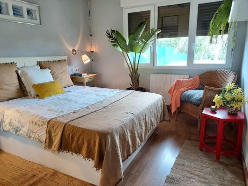 um quarto com uma cama, uma cadeira e uma janela em precioso chalet em Gijón