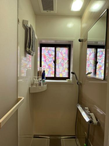 a bathroom with a toilet and stained glass windows at 浪漫宿花町 in Mitarai