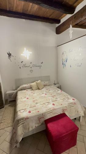 Un dormitorio con una cama grande con un cojín rojo en Casa medievale Il Rifugio di Olimpia, en Viterbo