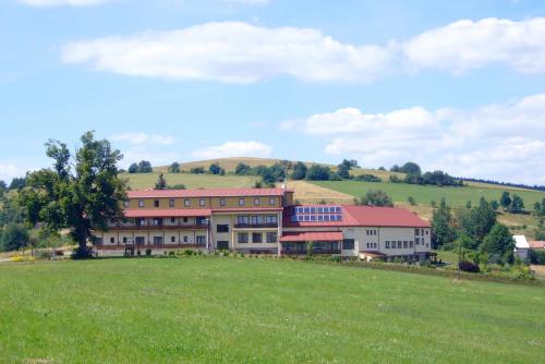 a building on a hill with a green field at Hotel Kopanice in Žitková