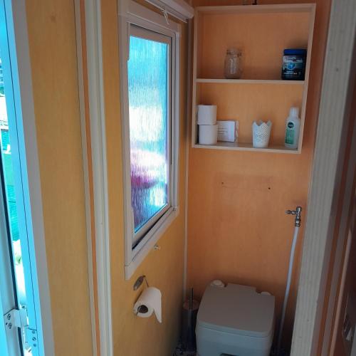 a small bathroom with a toilet and a window at Casa das Amoras in Santo António das Areias