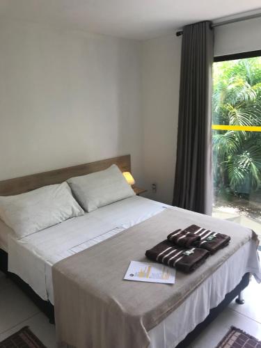 a bedroom with a bed with two towels on it at AYRE GOSTOSO POUSADA in São Miguel do Gostoso