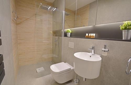 a bathroom with a toilet and a sink and a shower at Apartamenty Bryza-Baltycki - Apartamenty przy plaży z parkingiem in Świnoujście