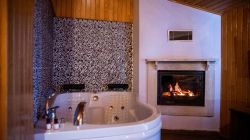 a bathroom with a tub and a fireplace at DEFNE OTEL in Şile