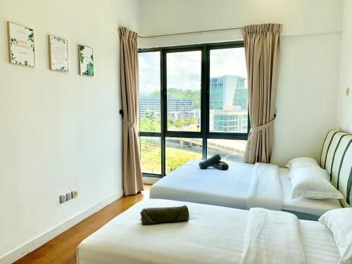 a bedroom with two beds and a window with a view at Deco Home @ Imago The Loft in Kota Kinabalu