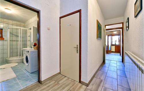 ein Bad mit einer Tür, die zu einem WC und einem Waschbecken führt in der Unterkunft Nice Home In Gudovac With Kitchen in Gudovac