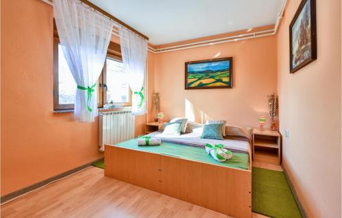 ein Schlafzimmer mit einem Bett in einem Zimmer mit orangefarbenen Wänden in der Unterkunft Nice Home In Gudovac With Kitchen in Gudovac