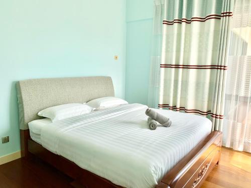 a bedroom with a large white bed with a teddy bear on it at Deco Home @ Imago The Loft in Kota Kinabalu