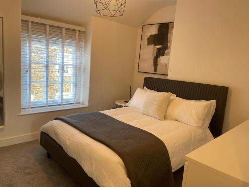 a bedroom with a bed and a window at Lux Cottage Conwy in Conwy