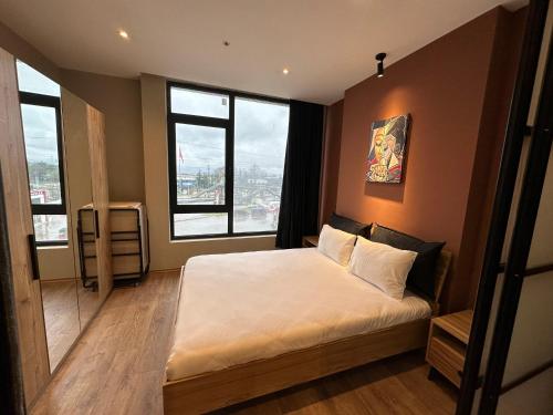 a bedroom with a bed with white sheets and windows at Bureau residence in Kartepe