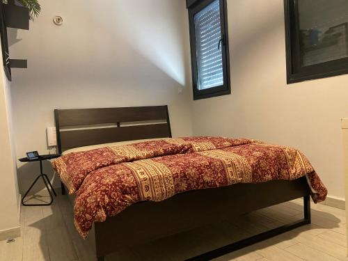 1 cama con edredón rojo en un dormitorio en Beauty apartment 3 rooms wi-fi, en Netanya