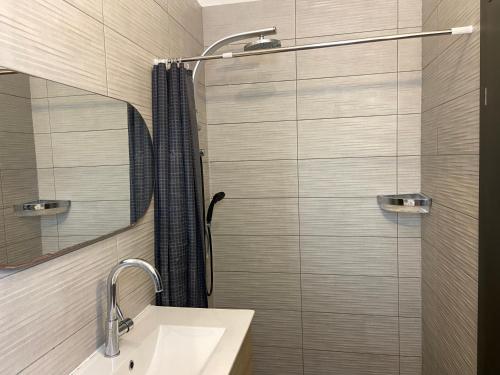 a bathroom with a shower with a sink and a mirror at Beauty apartment 3 rooms wi-fi in Netanya