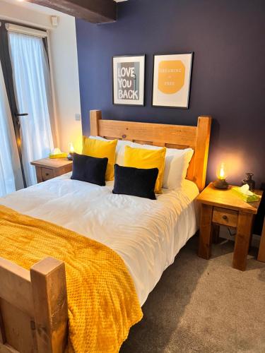 sypialnia z dużym łóżkiem z żółtą pościelą i poduszkami w obiekcie Stunning Liverpool City Center Apartment w Liverpoolu
