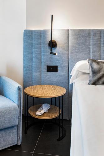 a bed room with a table next to a bed at Reflection Boutique Hotels in Toscolano Maderno