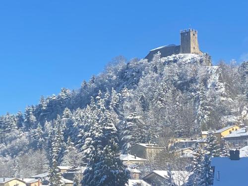 uma montanha coberta de neve com um castelo no topo em La finestra sul castello em Sestola