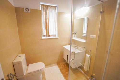 a bathroom with a toilet and a glass shower at Willows Cottage - Little England Cottages in Nuwara Eliya