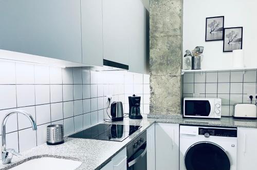 a white kitchen with a sink and a dishwasher at Vivienda Turística las Ciencias in Valencia