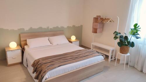 1 dormitorio con 1 cama, 2 lámparas y una planta en B&B Le Albarelle en Alba