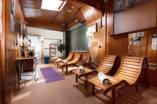 a row of wooden chairs in a room at Hotel Flora in Milano Marittima