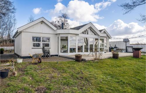 a white house with large windows and a yard at Nice Home In Kirke Hyllinge in Kirke-Hyllinge