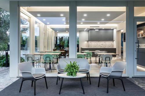 una sala da pranzo con tavoli, sedie e schermo di Reflection Boutique Hotels a Toscolano Maderno