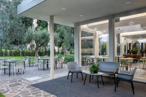 a restaurant with tables and chairs and windows at Reflection Boutique Hotels in Toscolano Maderno