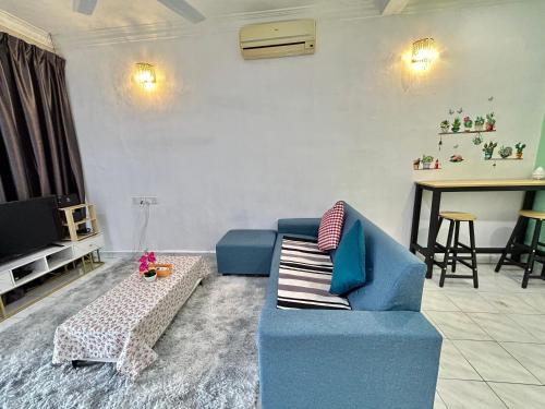 a living room with a blue couch and a table at Home14#2pax#Wifi&Netflix#NearAeonAlma&Lotus in Bukit Mertajam