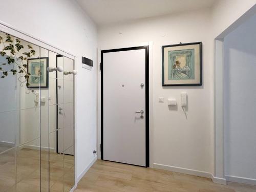 Łazienka z białymi ścianami i szklanymi drzwiami w obiekcie Casa Gio w Grado
