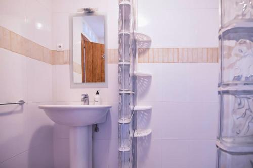 a white bathroom with a sink and a mirror at Luxury Villa Christine sea view in El Campello