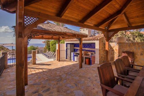 a patio with a wooden pergola and a pool at Luxury Villa Christine sea view in El Campello