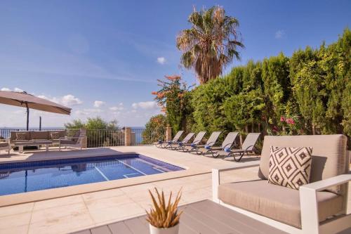 a pool with lounge chairs next to a swimming pool at Luxury Villa Christine sea view in El Campello
