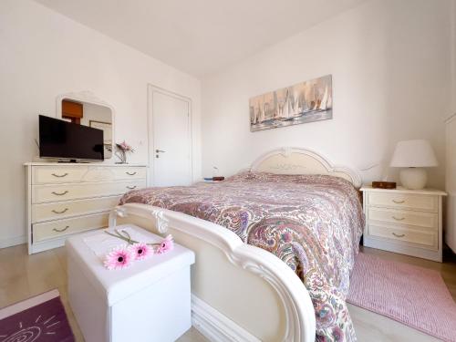 sypialnia z białym łóżkiem i białą komodą w obiekcie Casa Gio w Grado