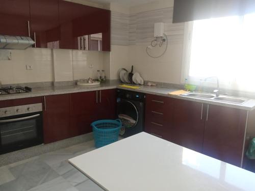 a kitchen with brown cabinets and a sink at Nouvel appartement climatisé in Fez