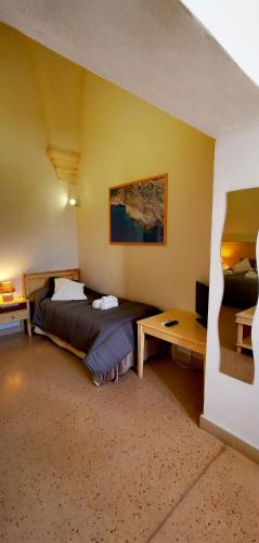 a hotel room with a bed and a desk and a bed sidx sidx at Casina Raho B&B in Nardò