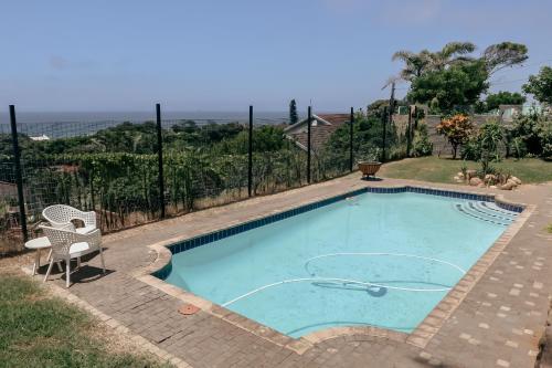 a swimming pool with a chair and a fence at Ocean Rocks Villa, Umhlanga in Durban