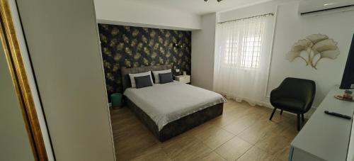 a bedroom with a bed and a chair in it at Luxury apartment Private parking self check-in51 in Craiova