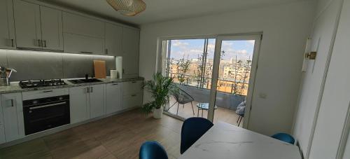 a kitchen with white cabinets and a view of a city at Luxury apartment Private parking self check-in51 in Craiova
