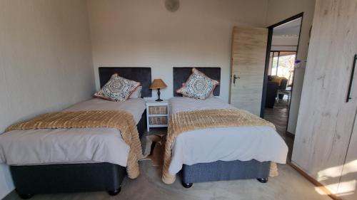 two twin beds in a room with a hallway at Sonop in Marloth Park in Marloth Park