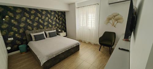 a bedroom with a bed and a chair in it at Luxury apartment Private parking self check-in51 in Craiova