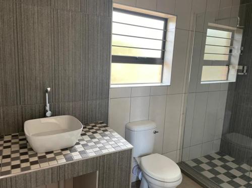 La salle de bains est pourvue de toilettes, d'un lavabo et d'une baignoire. dans l'établissement Sonop in Marloth Park, à Marloth Park