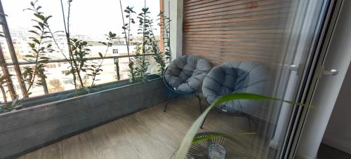 a balcony with two chairs in front of a window at Luxury apartment Private parking self check-in51 in Craiova