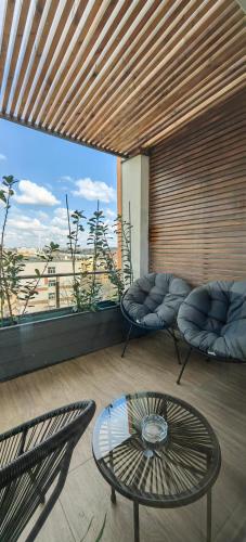 a balcony with two chairs and a table and a window at Luxury apartment Private parking self check-in51 in Craiova