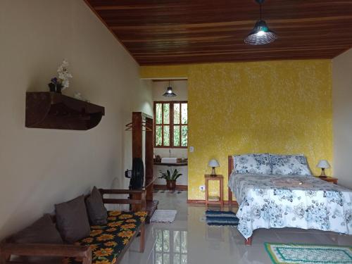 a bedroom with a bed and a couch at Recanto bela Vista caminho do ouro in Paraty