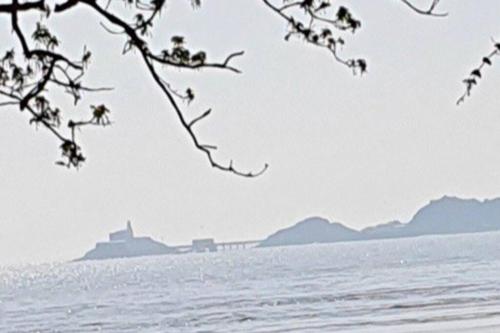 a view of the ocean with a bridge in the background at Luxury Mumbles View Studio Apartment in Swansea