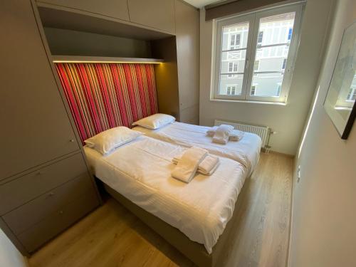 Edward Hopper Suite, Duinhof 3-9-7, spacious apartment near the beach with sunny balcony في كادزاند: غرفة نوم صغيرة عليها سرير وفوط