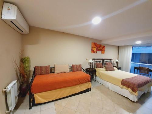 Una habitación de hotel con dos camas y una ventana. en Departamento Caseros, en Salta