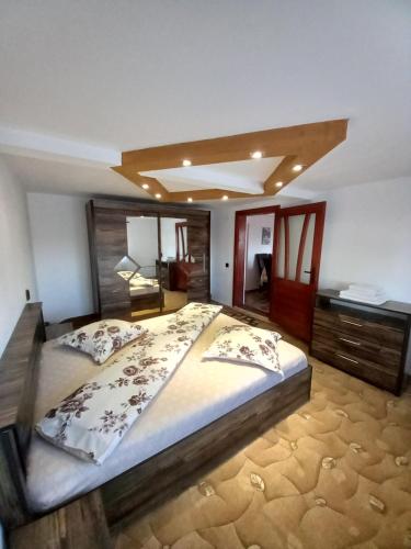 a bedroom with a large bed and a desk at Casa David in Gîrda de Sus